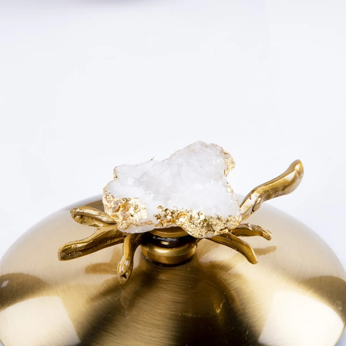 Close-up of the gold lid with a crystal-like top detail