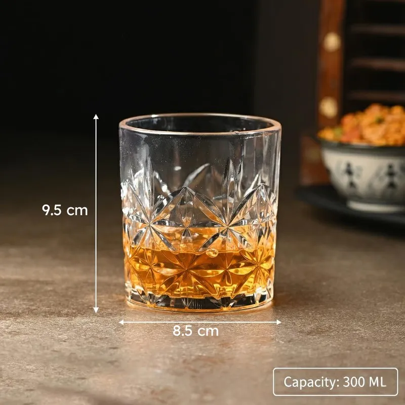 Single clear textured whiskey glass with amber drink