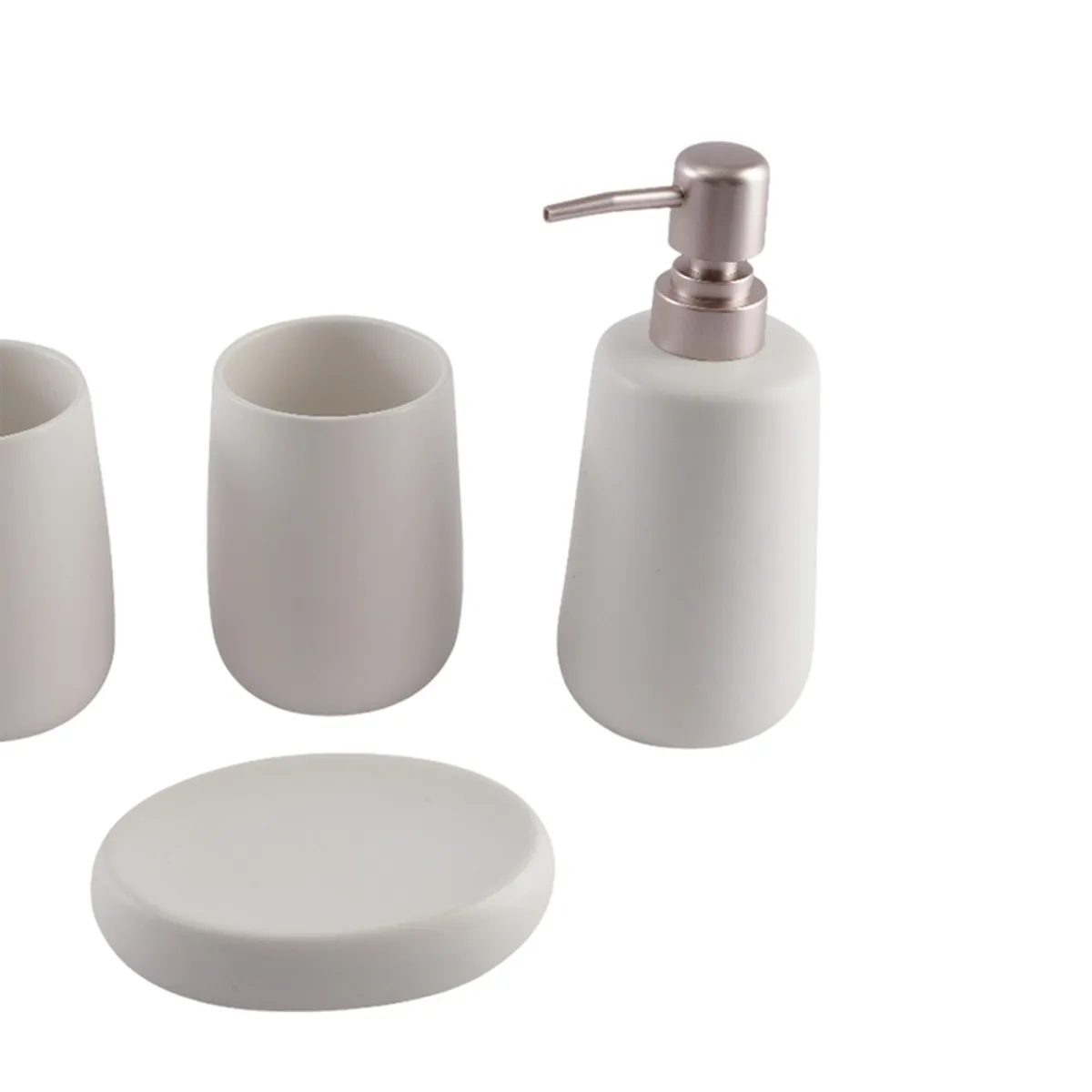 Close view of white ceramic tumbler, soap dispenser and soap dish