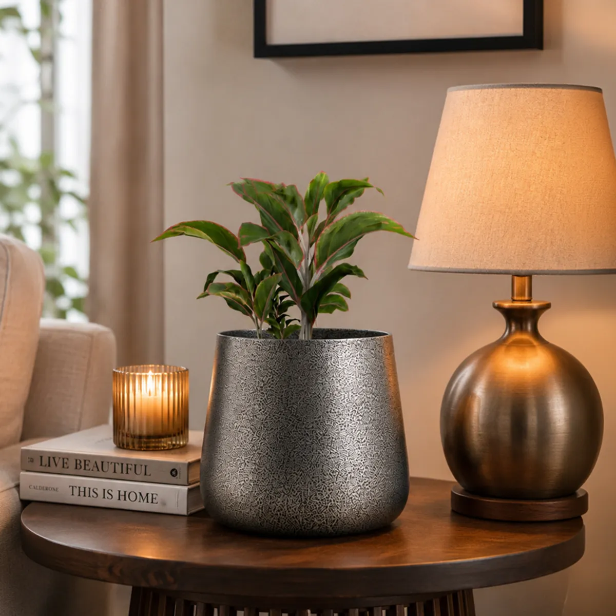 Grey textured planter styled with a green plant on a round wooden table