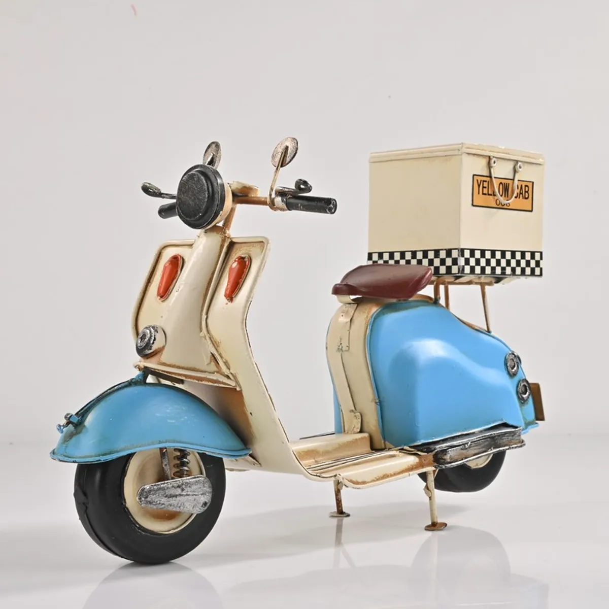Blue and cream scooter iron showpiece on a plain white background