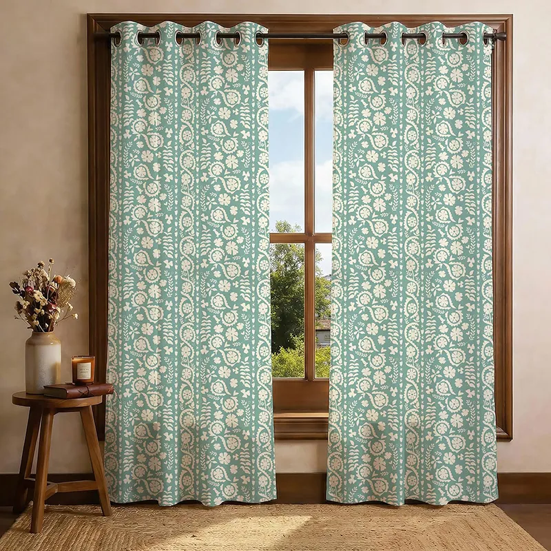 Set of two green floral printed curtains hung on a wooden window