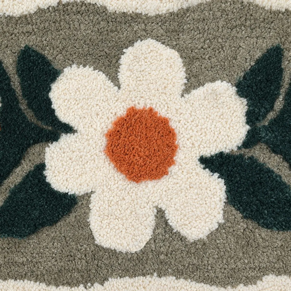 Close-up of a cream flower with orange centre and dark green leaves