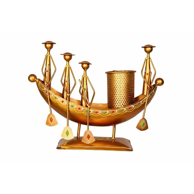 Front view of a gold metal boat-shaped pen stand with figurative details