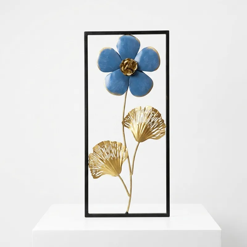 Rectangular metal wall accent with flower and foliage design on a white pedestal