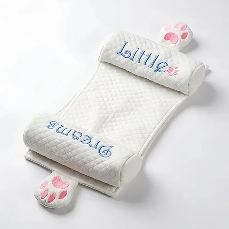 White quilted baby neck pillow with blue lettering and pink paw accents