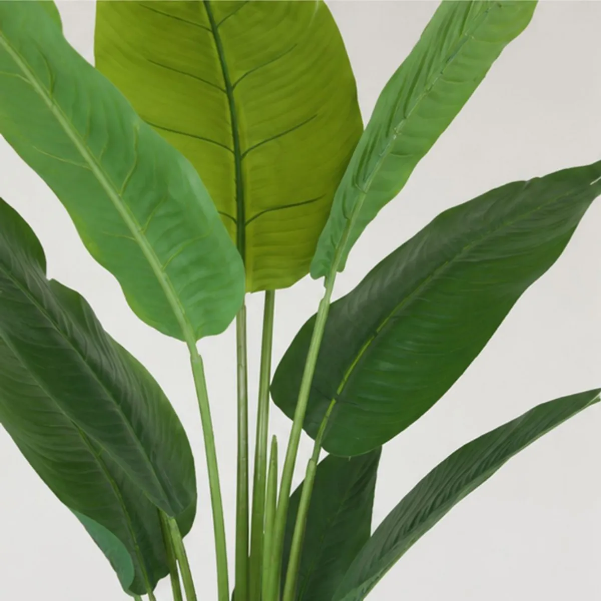 Close-up of large green artificial leaves with visible central veins and layered foliage