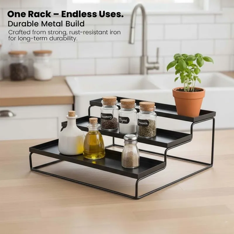 Black tiered metal organiser styled on a kitchen counter with spice jars and a plant.