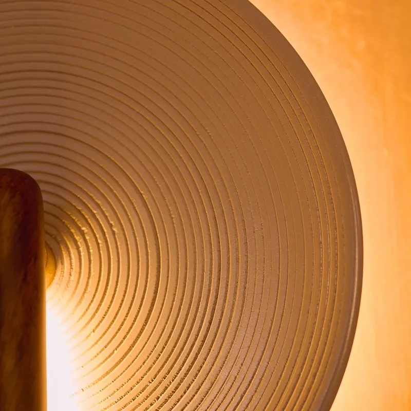 Close-up of the lamp's ridged circular shade with warm backlight