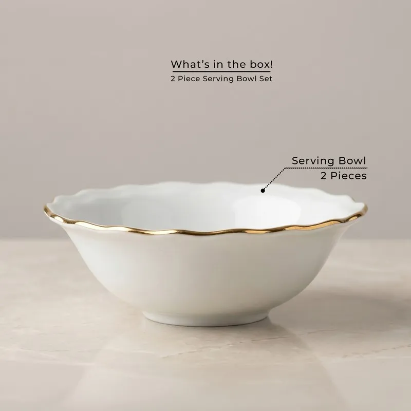 Single white serving bowl with a scalloped gold rim on a neutral surface