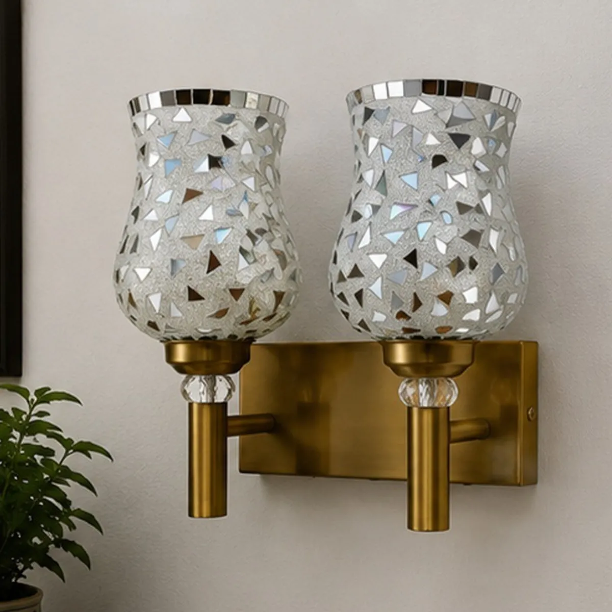 Mosaic glass wall lamp with two shades shown unlit against a light wall.