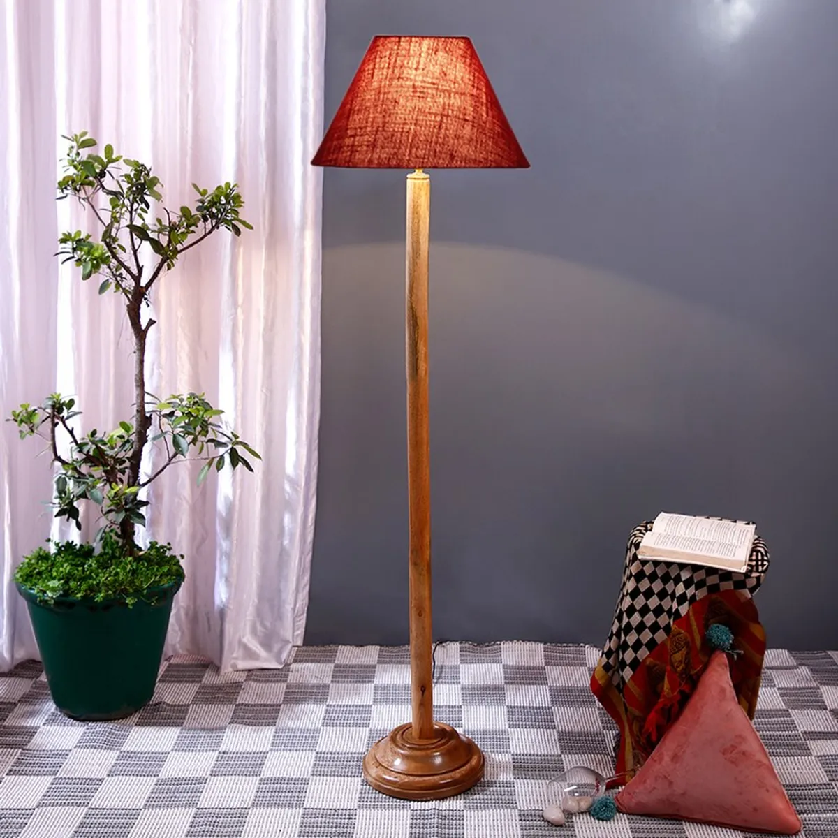 Burgundy shade floor lamp with wooden base in a styled room setting