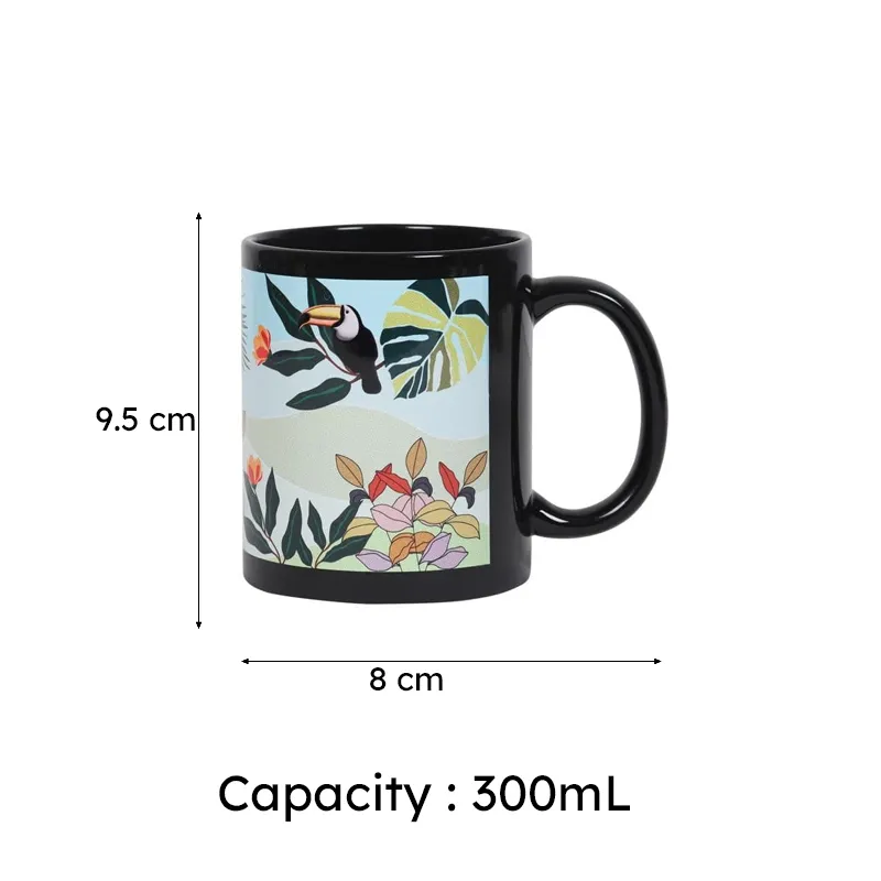 Black mug with toucan and colourful foliage artwork shown with 8 cm by 9.5 cm dimensions