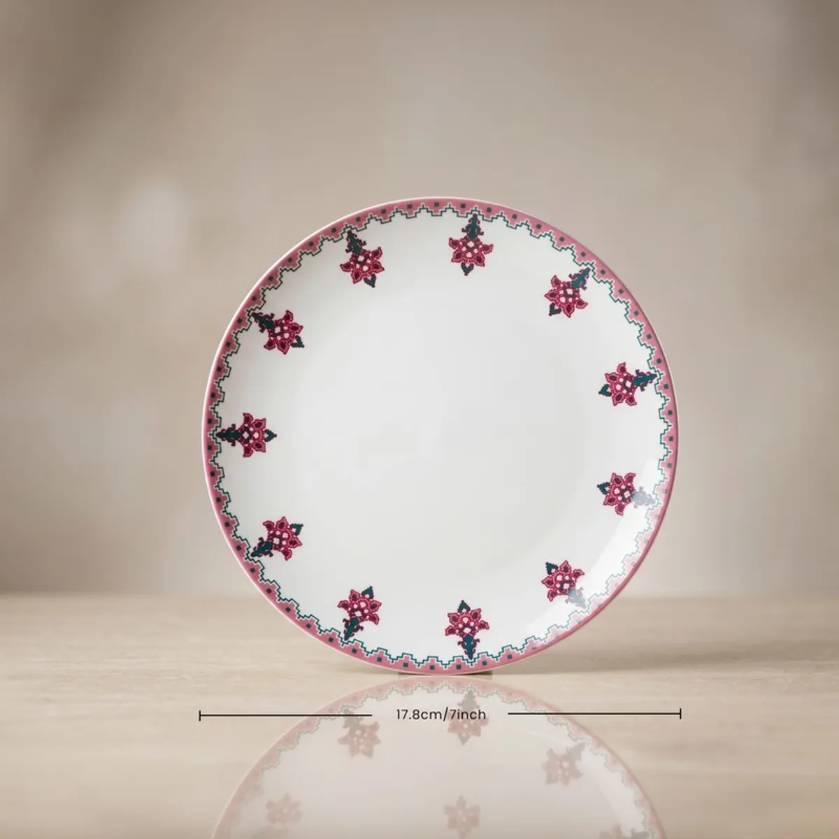 Front view of a round pink and white floral quarter plate.