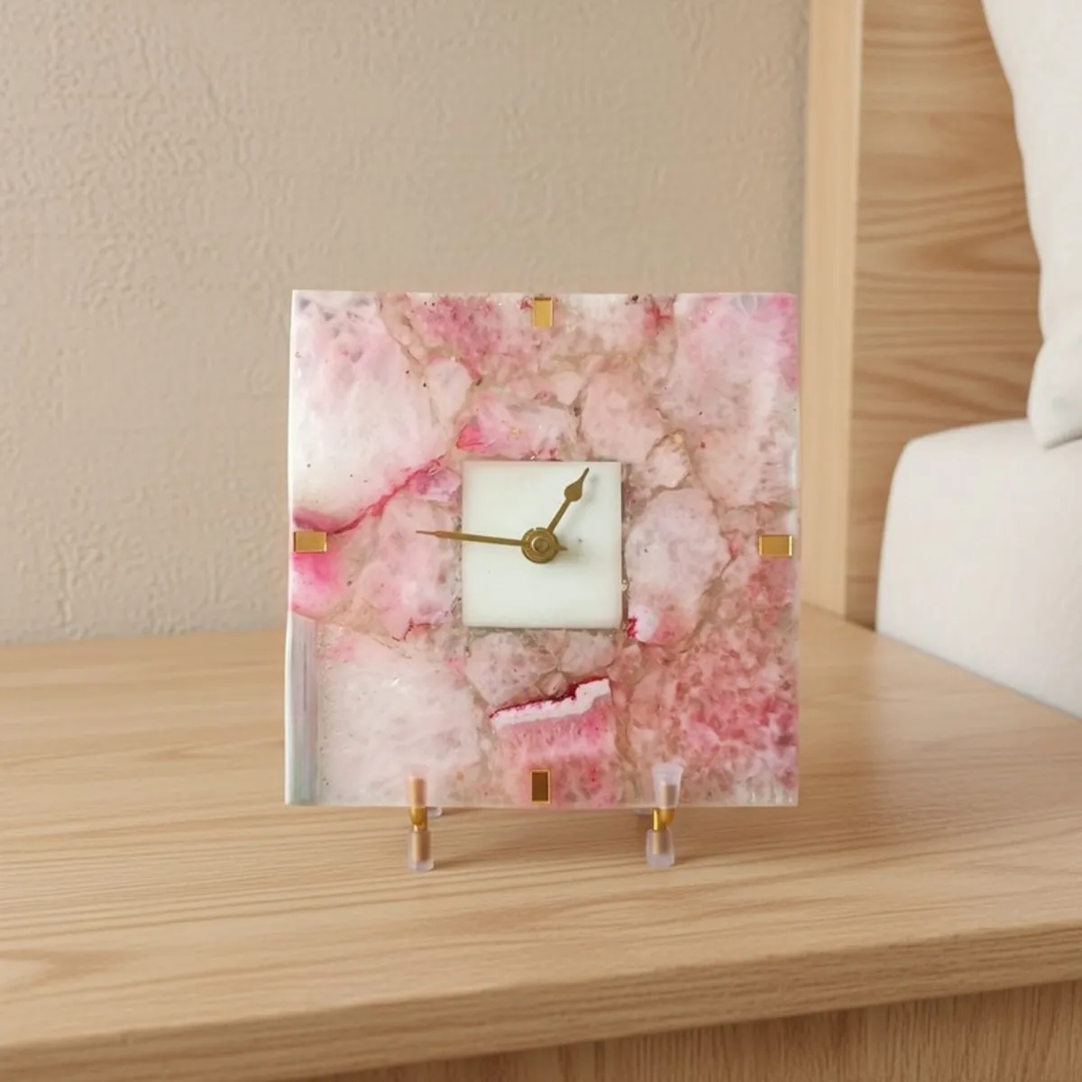 Pink agate table clock with gold accents styled on a bedside table