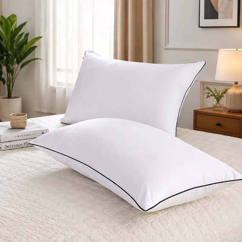 Two white pillow fillers displayed on a bed, one upright and one lying flat
