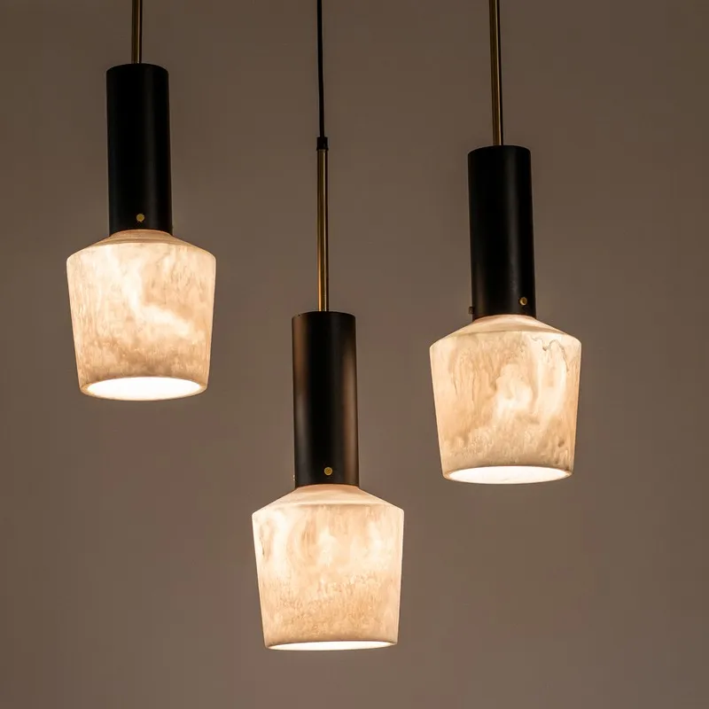 Lit trio pendant ceiling lamp with softly glowing alabaster-look shades