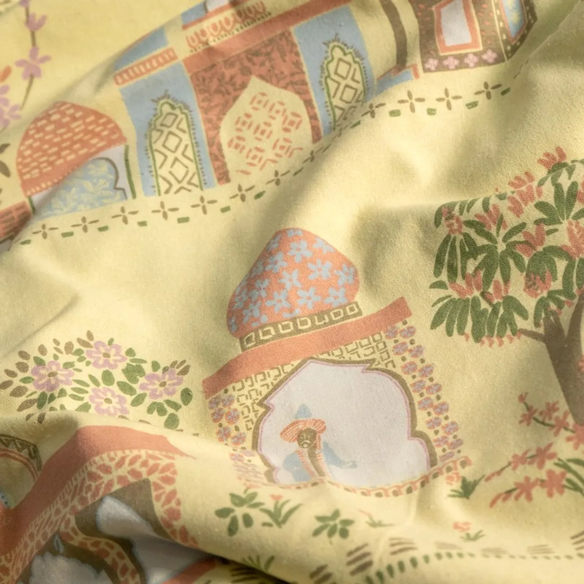 Close-up of yellow cotton curtain fabric with colourful palace motifs