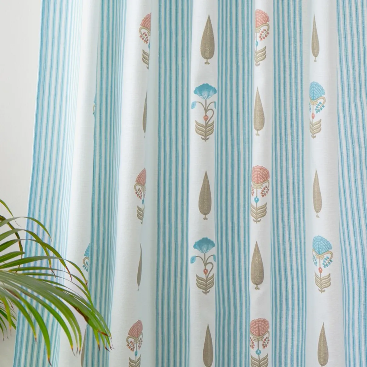 Detailed view of blue-striped curtains with colourful floral and leaf motifs