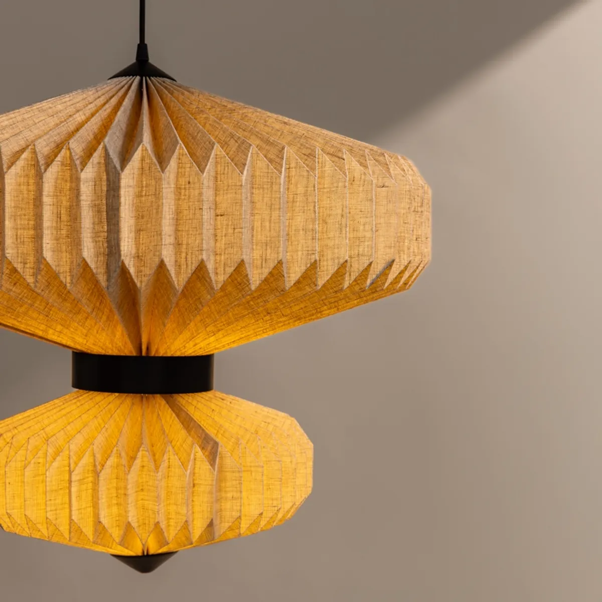 Close-up of lit pleated beige paper shade on pendant lamp