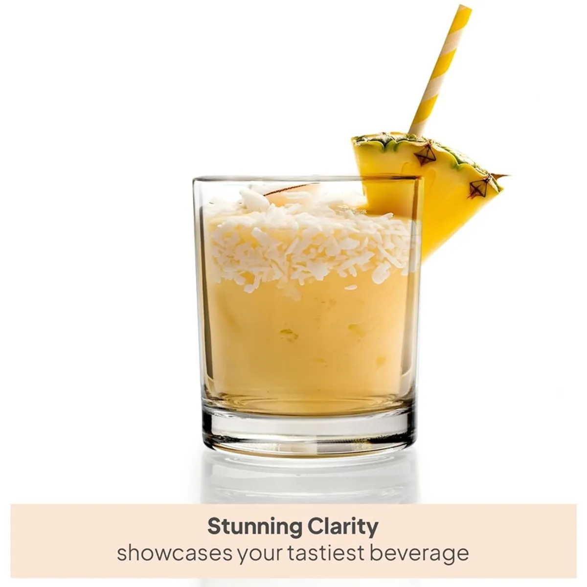 Close-up of a clear glass holding a pineapple drink with a striped straw
