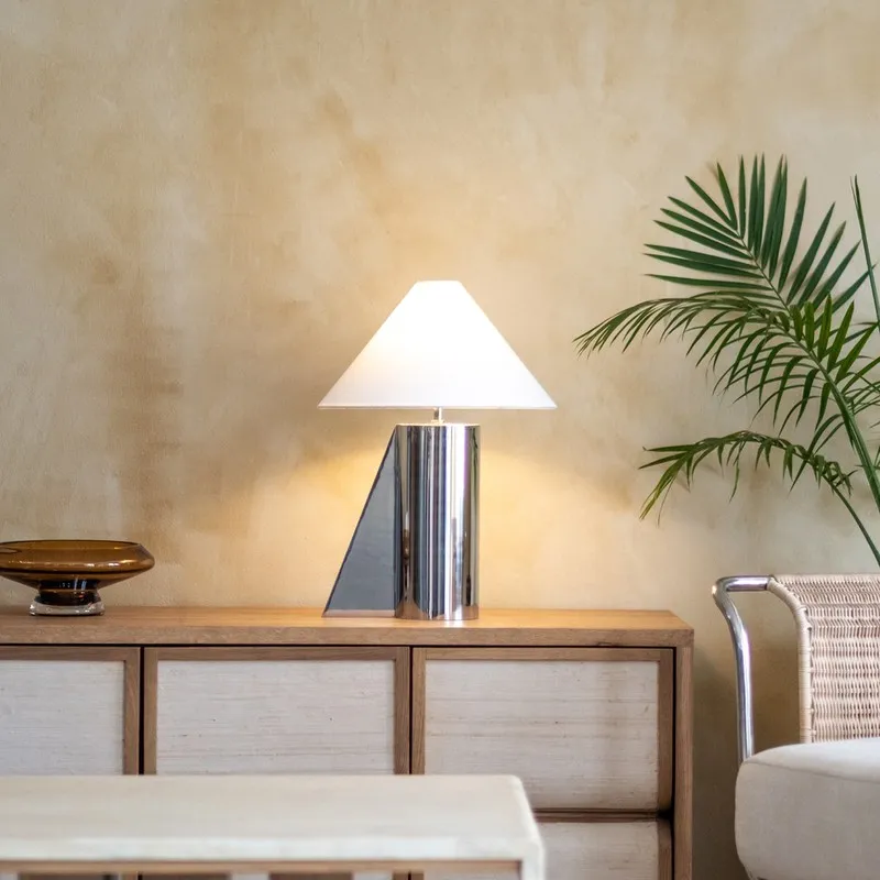 Contemporary silver table lamp with white shade styled on a sideboard