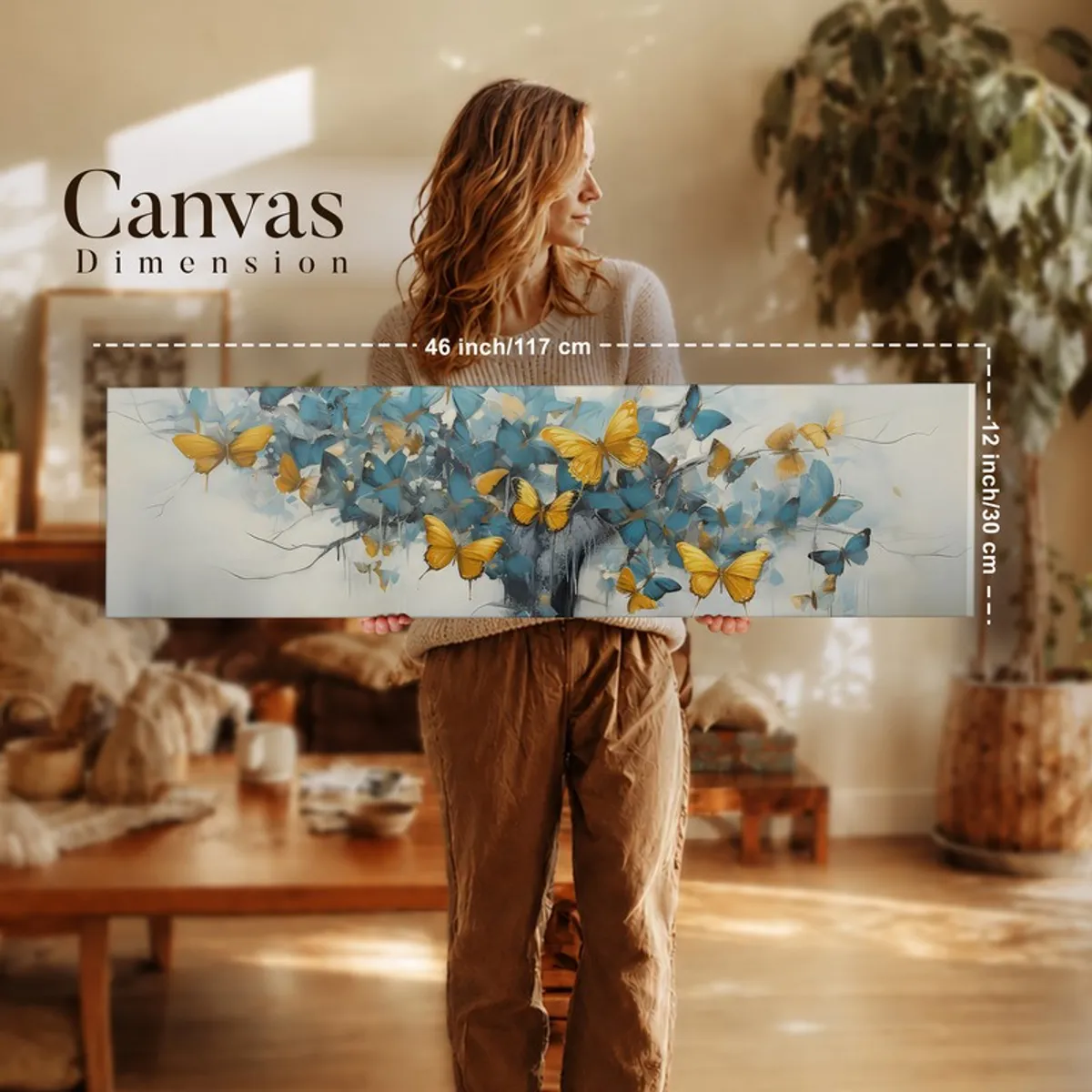 Person holding a panoramic butterfly canvas artwork in a softly lit interior