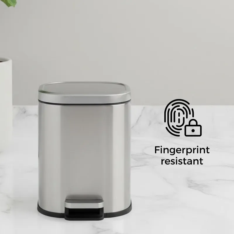 Silver pedal dustbin with closed lid on a marble counter