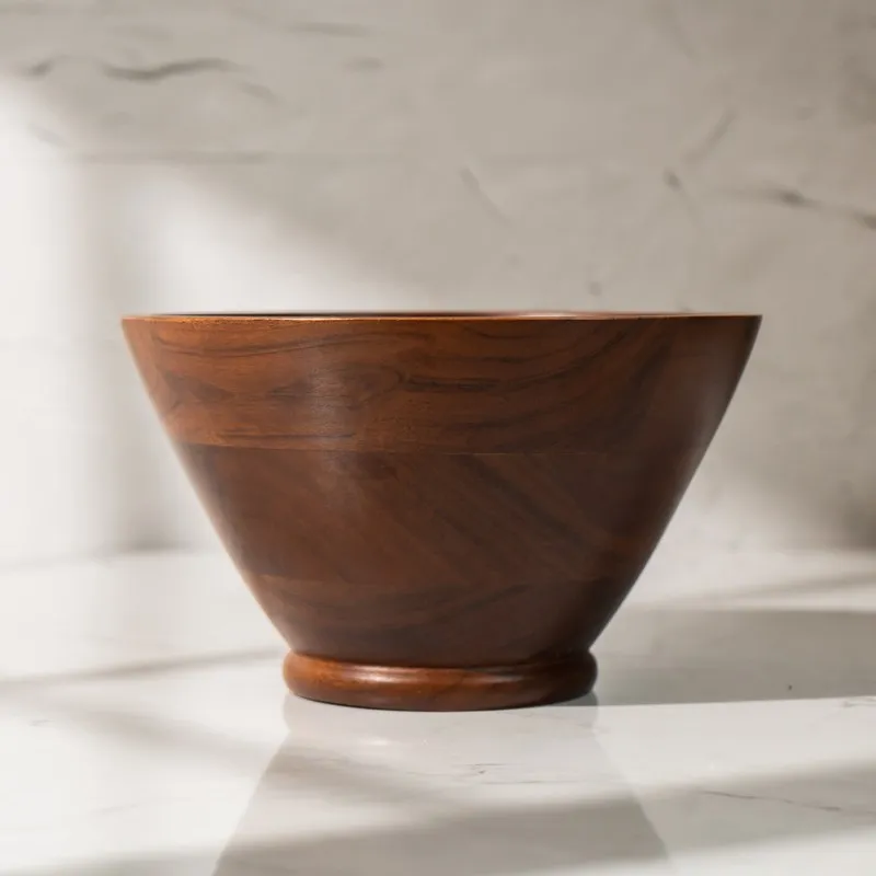 Side view of the brown wooden bowl showing its conical shape and raised base