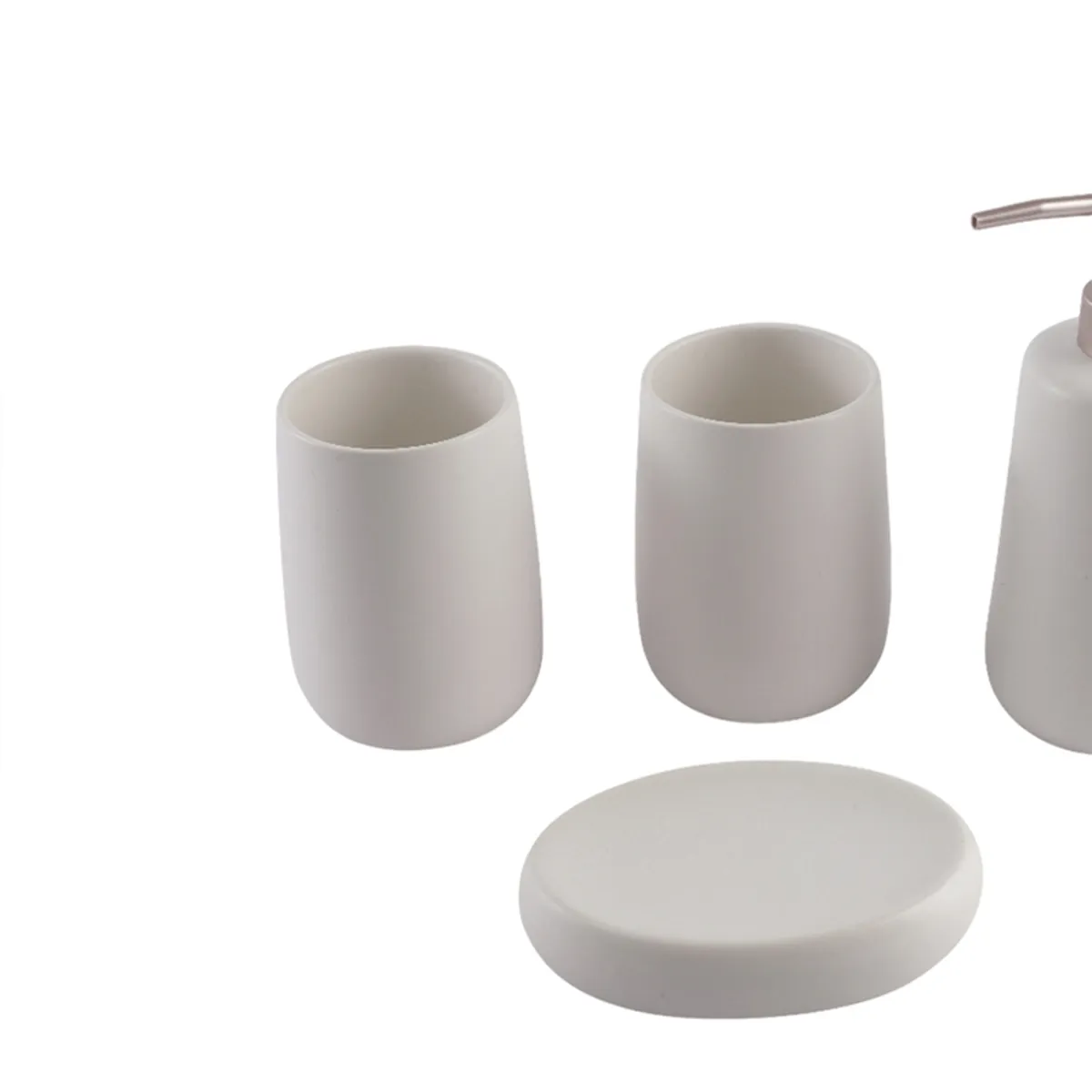Close view of white ceramic toothbrush holder, tumbler and soap dish