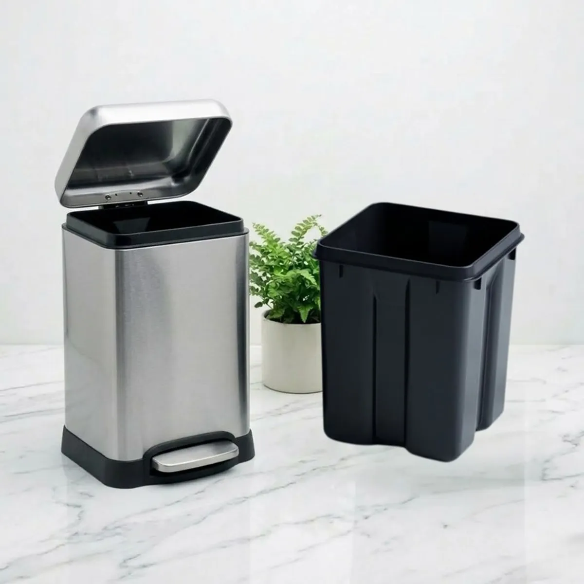Silver dustbin with lid open beside a removable black inner bin