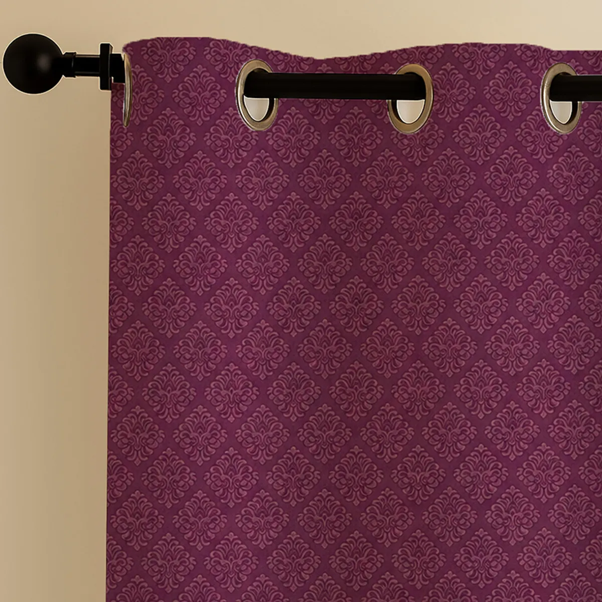 Close-up of maroon patterned curtain with eyelet rings on a rod