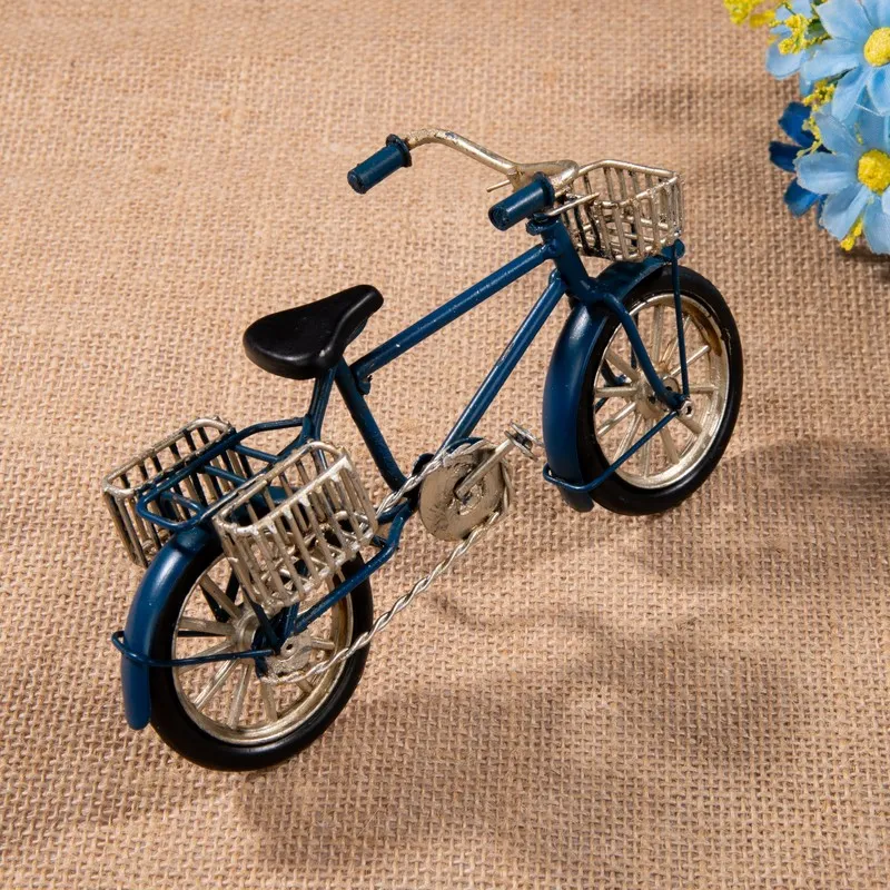 Dark blue miniature bicycle showpiece with silver baskets on textured fabric