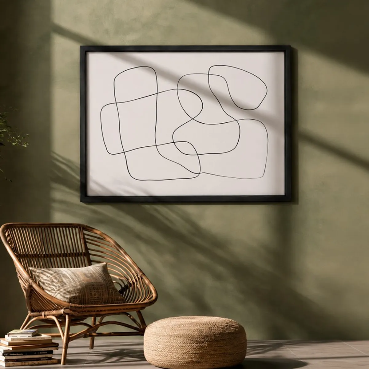 Framed abstract line artwork on a muted green wall above a chair