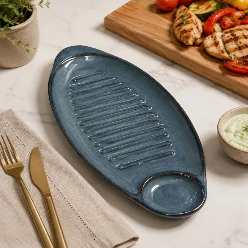 Empty glossy blue oval platter with raised ridges and dip section