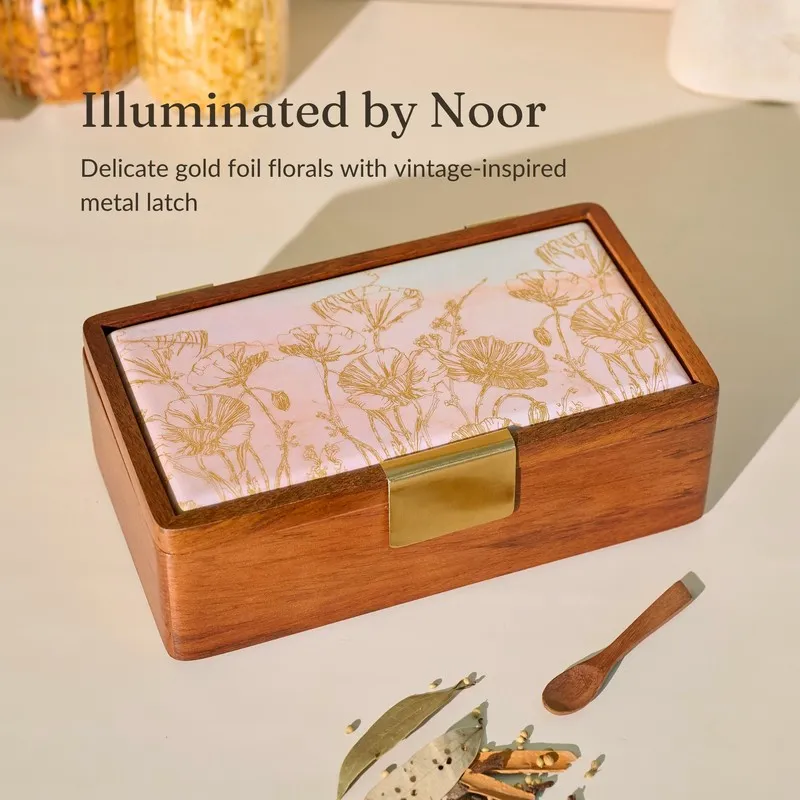 Brown masala box showing its pale lid with delicate gold floral detailing