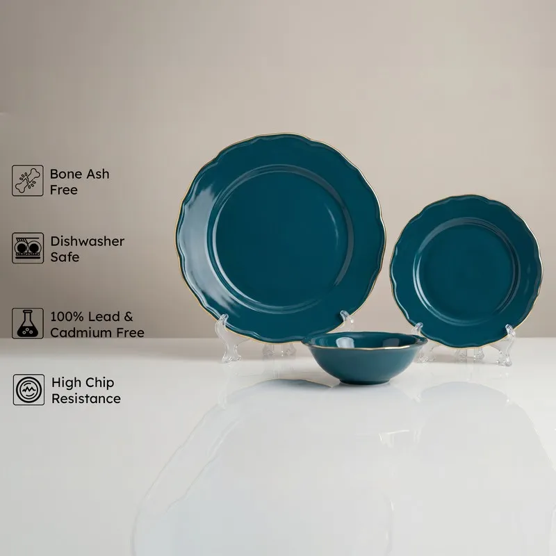 Dark teal dinnerware set with gold rims showing plate, side plate and bowl.