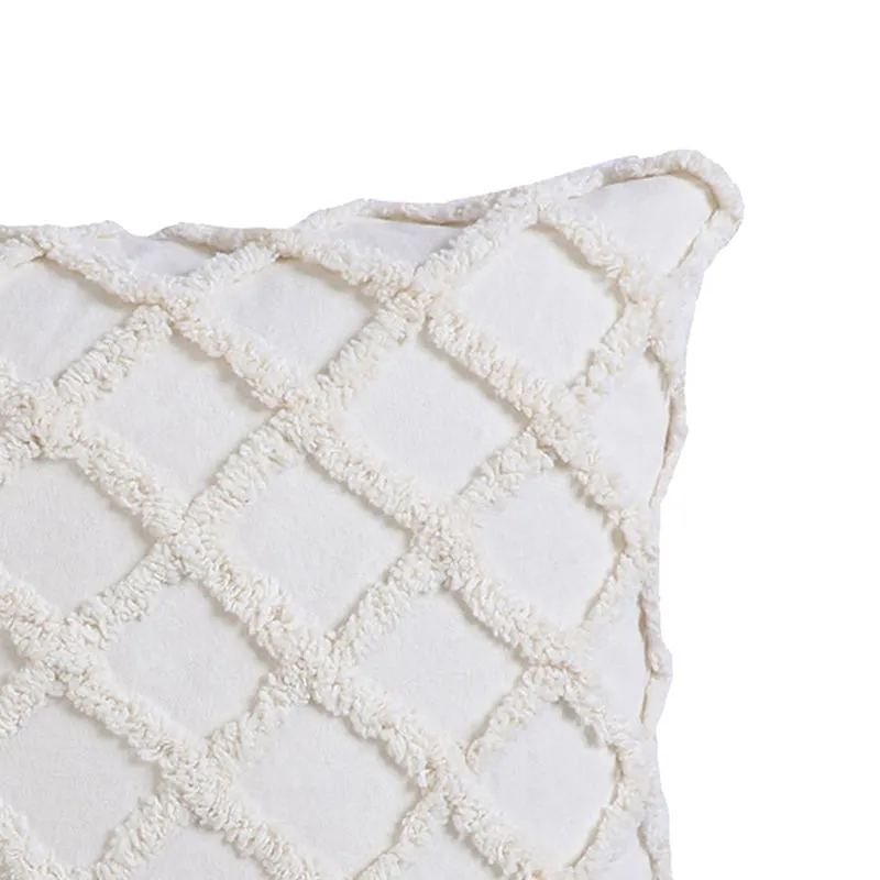 Close-up of one corner of the white tufted cushion cover.