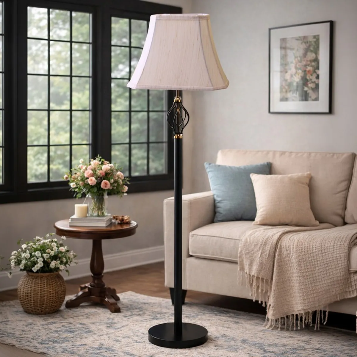 Black floor lamp with beige pleated shade styled near a sofa and round side table