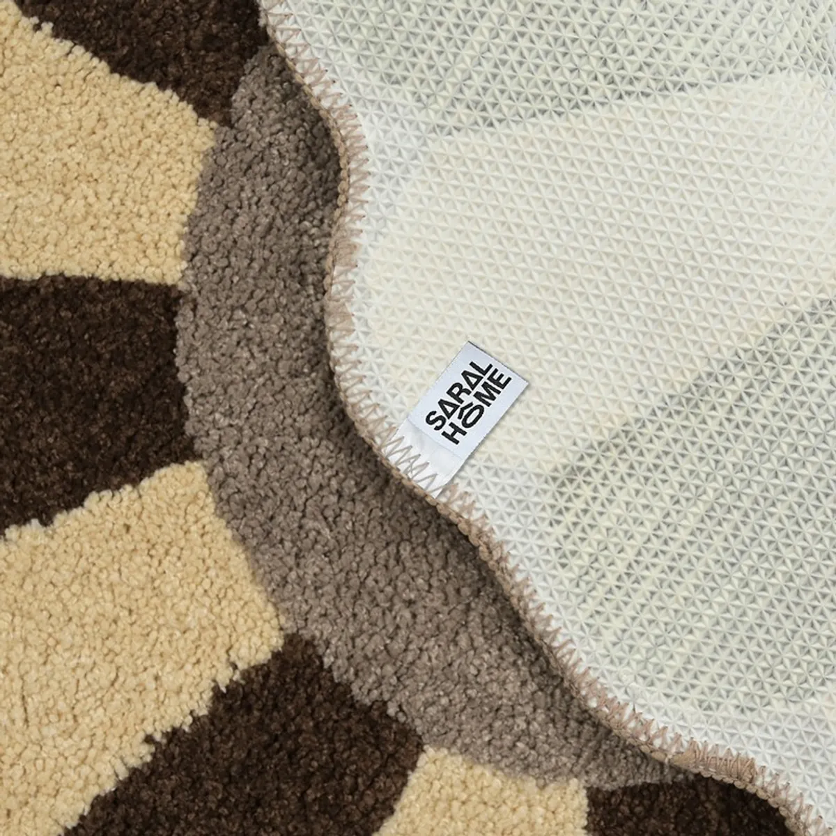 Underside of a flower-shaped bath mat showing its white anti-skid backing