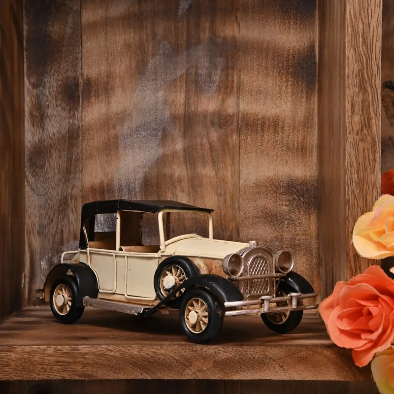 Beige vintage model car showpiece displayed on a wooden shelf