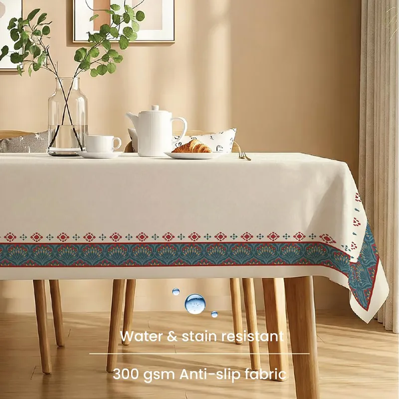 Side view of off-white table cover with teal and red decorative border