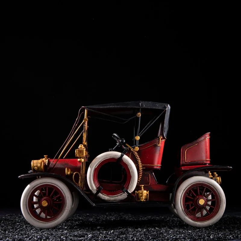 Side view of red vintage car decorative showpiece with white tyres