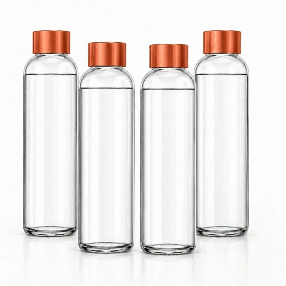 Four clear cylindrical glass water bottles with metallic gold caps on a white background