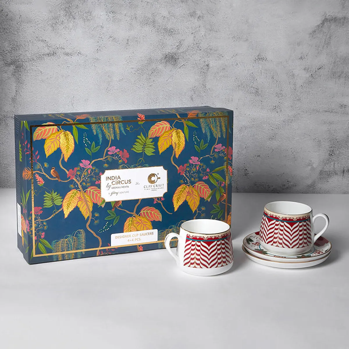 Gift box and two red chevron cup and saucer pairs on a tabletop