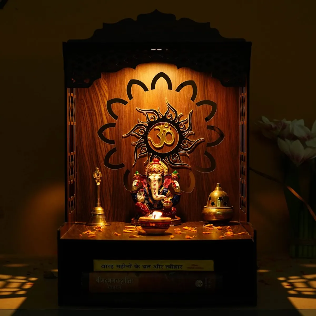 Lit wooden mandir showing warm glow and Om motif backdrop