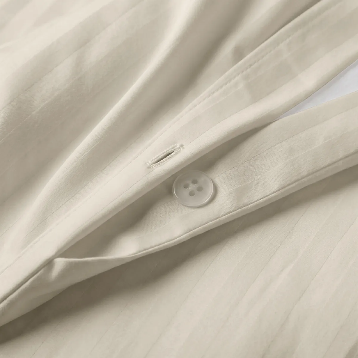 Close-up of the duvet cover fabric and button fastening in off-white