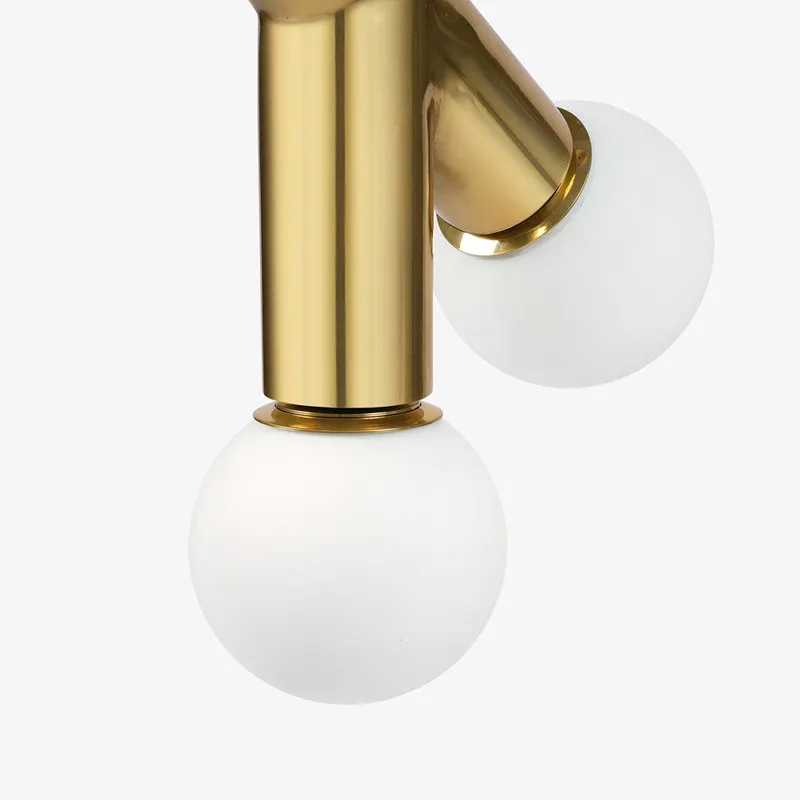 Close-up of white globe shades on a gold ceiling lamp