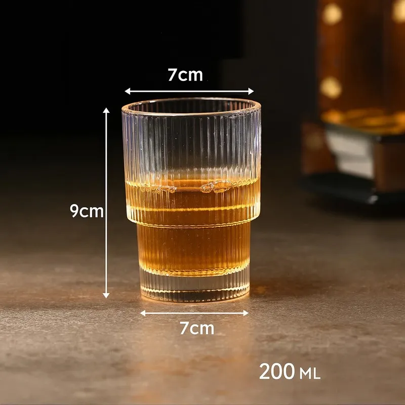 Clear ribbed cocktail glass filled with amber drink with size markings shown