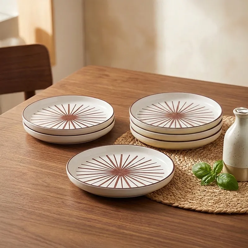 Set of maroon and white snack plates arranged on a wooden dining table